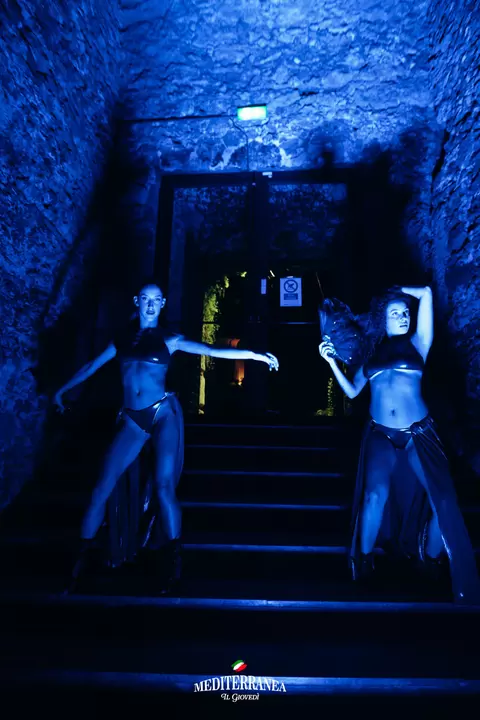 Due performer sulla scalinata di pietra illuminata di blu